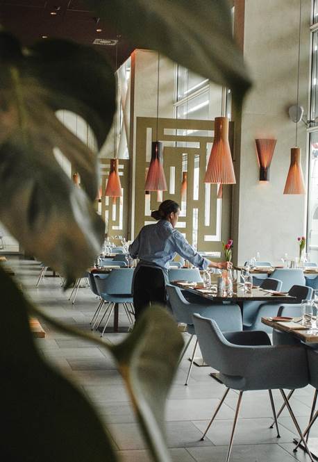 Mann deckt Tische in einem modernen Restaurant